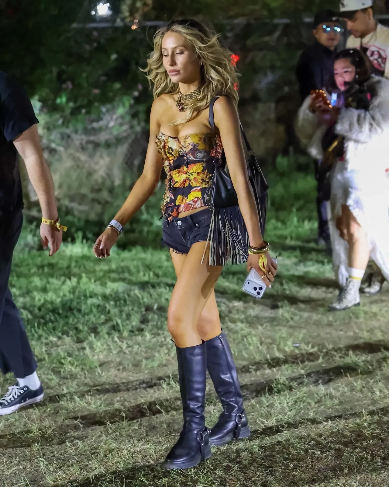 Alix Earle diện đôi giày mẫu Hillstar đính dây đai (harness) của thương hiệu Bared Footwear, phối cùng áo corset chắp vá của Roberto Cavalli, quần short bò sờn gấu và vòng cổ choker vintage layer nhiều lớp.