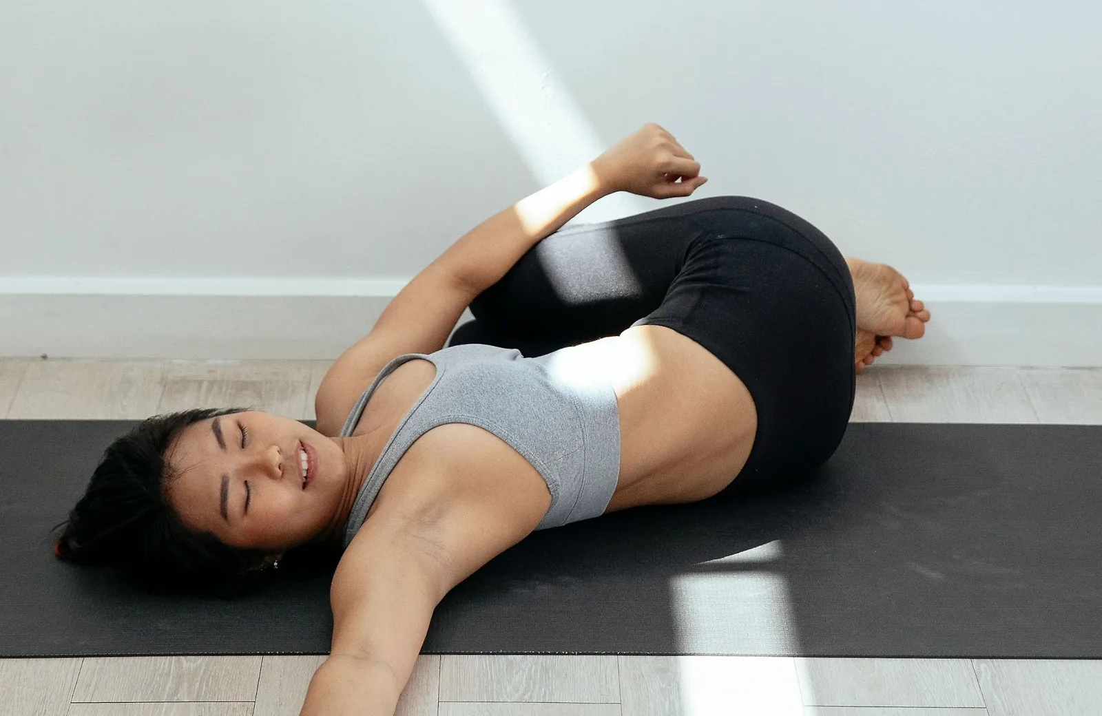 Thực hiện tư thế xoay người khi nằm để kéo giãn cột sống.